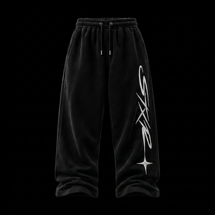 STXR extra-baggy black sweatpants with white embroidered cursive script down the leg and open hems